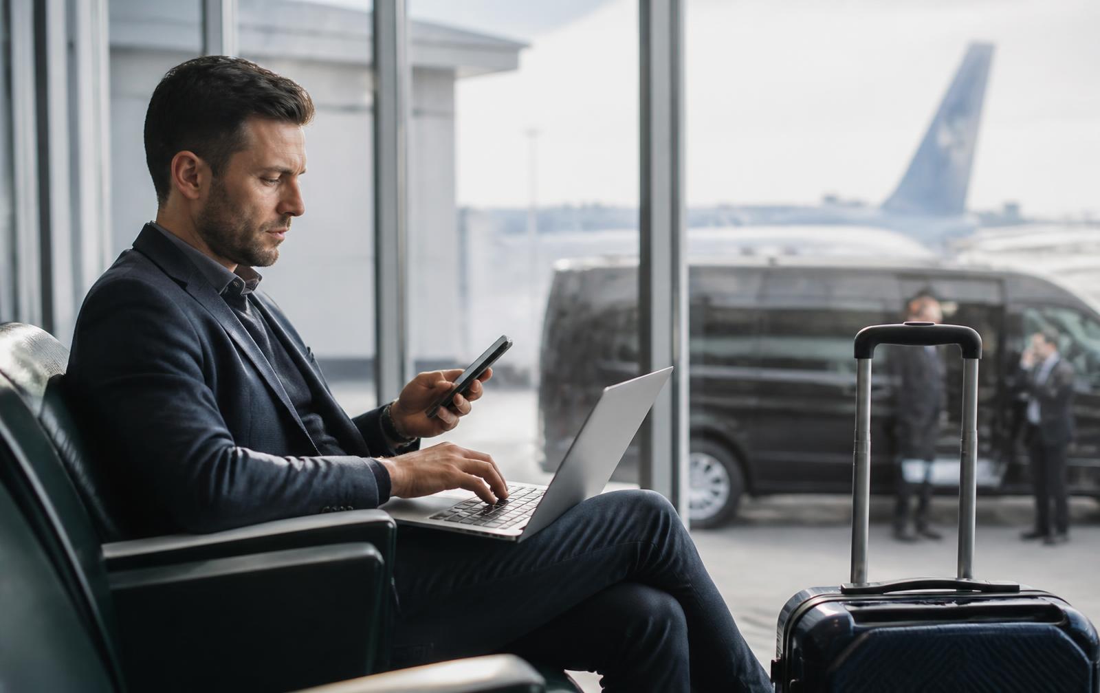 Traveler booking an airport transfer with luggage nearby