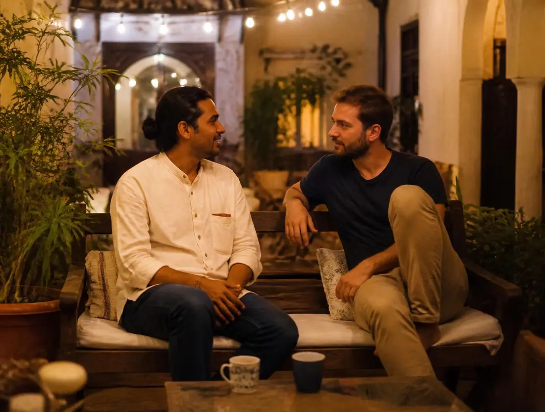 A host and a traveler talking in a courtyard in the evening